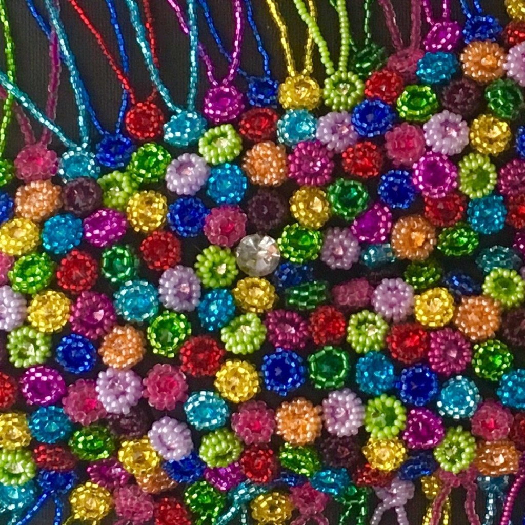 Detail of bead embroidery showing white crystal symbolizing a preserved memory.